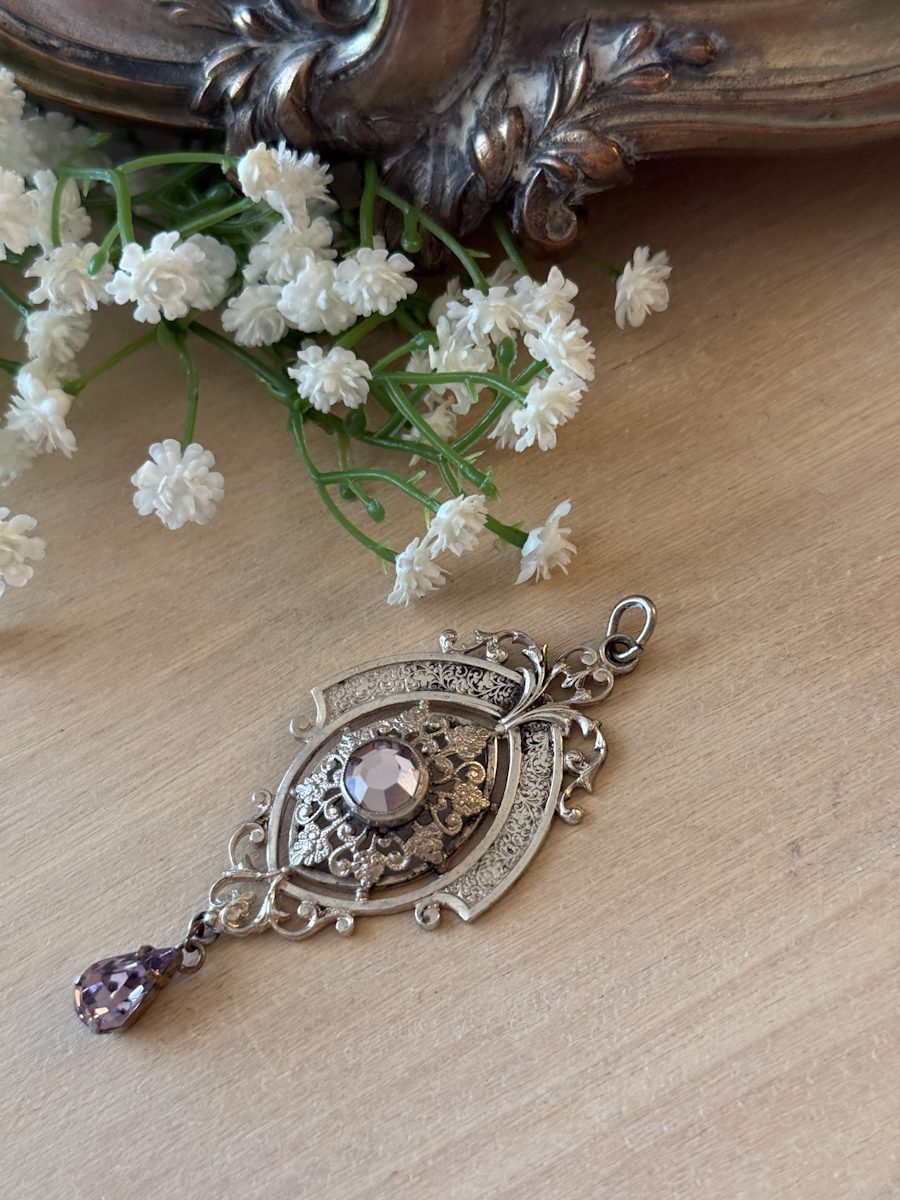 Antique Austro-Hungarian style silver pendant featuring a central oval frame, detailed engraving, and faceted amethyst-colored glass drops.