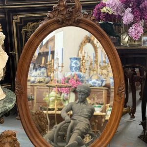 Antique French Rococo style walnut oval wall mirror with detailed shell cartouche cresting and thick bevelled glass.