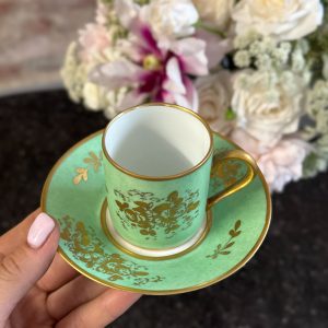 Spectacular antique french porcelain cup and saucer hand-decorated in a radiant empire green glaze with exquisite 24k gold leaf floral gilding, signed "Décoré main".