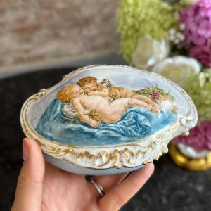 maza izmēra “Limoge” porcelāna trauciņš ar vāciņu/lādīte, apgleznots, gaiši zilā krāsā ar eņģeļu motīvu un zelta krāsas detalizāciju (7203)